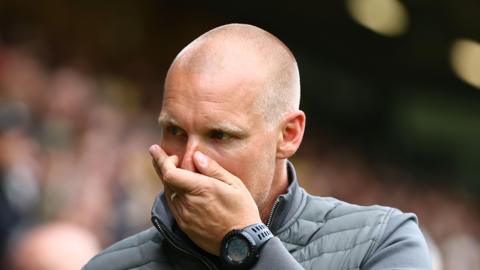Liam Manning with his hand over his mouth