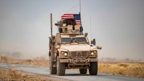 A US military vehicle drives in the vicinity of an oil field in in Syria