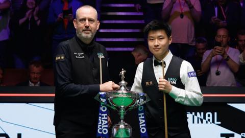 Mark Williams and Zhao Xintong with the World Snooker Championship trophy