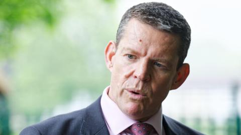 Rhun ap Iorwerth speaking into a camera