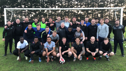 The Great Wakering Rovers squad pose in front of a goal