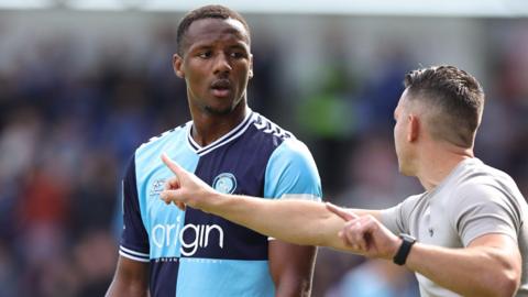 Wycombe Wanderers forward Richard Kone listens to head coach Matt Bloomfield at the side of the pitch.