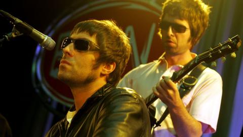 Liam and Noel Gallagher performing onstage