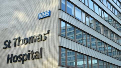 File image showing the St Thomas' Hospital sign of the side of a tiled hospital building with windows.