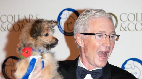 Paul O'Grady (right) holding a dog