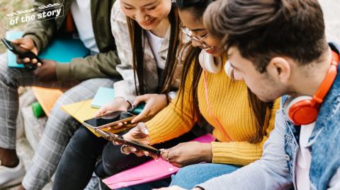 Teenagers look at mobile phones