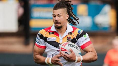 Guy Armitage of Bradford Bulls carries the ball, dressed in the team's red, amber, black and white