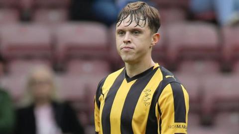Kyle John in action for Port Vale. He is wearing the club's yellow and black striped away shirt