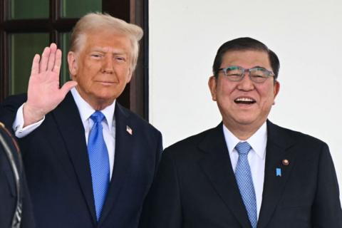 Donald Trump waving next to Japan's Prime Minister Shigeru Ishiba