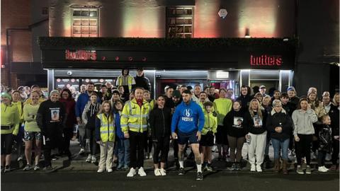 Runners in hi-viz jackets gather for a run