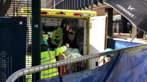 Final protester signalling out of the back of an ambulance