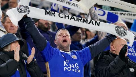 Leicester City fan holds up a scarf in memory of former Leicester City owner, Vichai Srivaddhanaprabha, who passed away 5 years ago ahead of the Championship match at King Power Stadium, Leicester