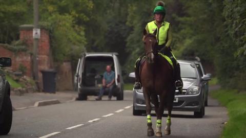 Alison on a horse on the road