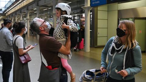 A father greets his daughter after arriving in a Eurostar train from Paris