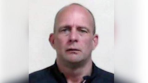 A head shot of David Brown, a man with a shaven head looking directly into the camera.