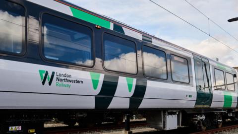 A LNR train, with green and black writing, showing several train windows.