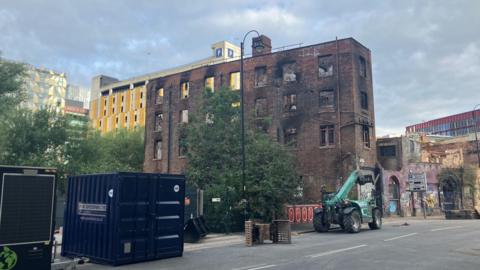 Photograph of the Hotspur Press building in Manchester city centre. It shows the damage - including blackened windows - caused by the recent fire. 