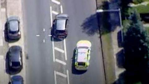 Aerial image from police helicopter shows police car in pursuit of a silver vehicle.