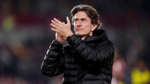 Thomas Frank applauds fans after a match