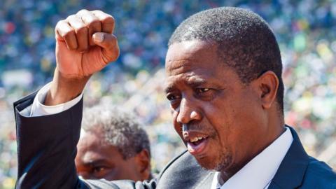 Edgar Lungu punching his fist into the air in a stadium