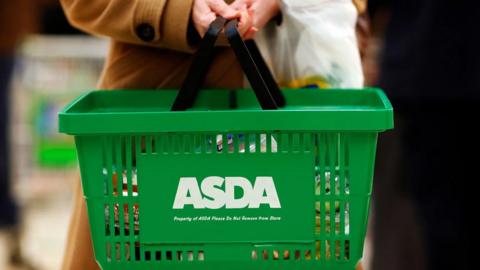 Woman holding a green ASDA basket
