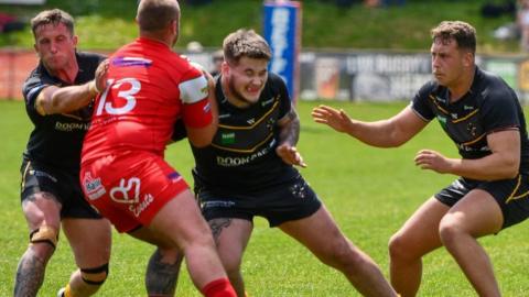 Cornwall players tackle an opponent from North Wales Crusaders