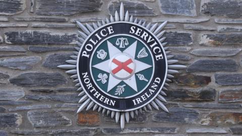 PSNI logo on a brick wall