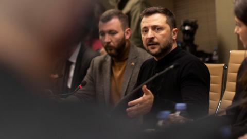 Volodymyr Zelensky (centre back row wearing a black military sweatshirt) speaks to a group of journalists in the UK on Sunday.