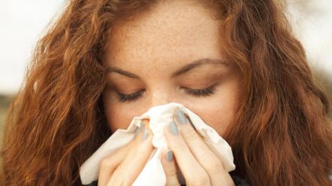 Woman blowing her nose