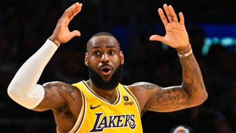 LeBron James holds his hands in the air during an LA Lakers game