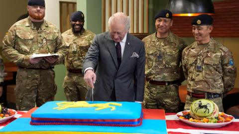 King Charles III cuts a cake during a visit to the Royal Regiment of Artillery at Baker Barracks, Thorney Island, West Sussex.