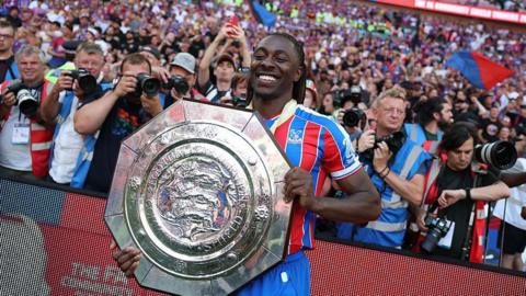 Crystal Palace player Ebererchi Eze stands with the Community Shield