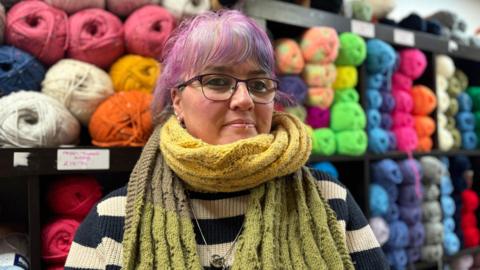 Woman with pink hair and stripy jumper