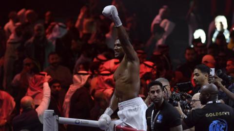 Anthony Joshua celebrates standing on the ropes