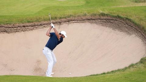 Scottie Scheffler takes a shot out of the bunker