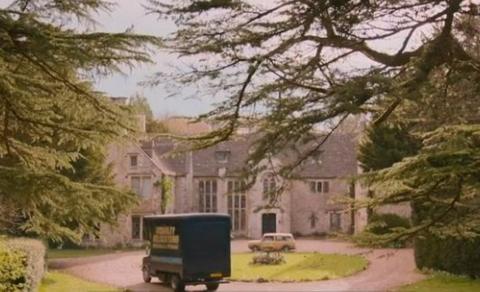 Van driving into front drive with mini roundabout, with trees 