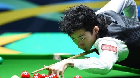 Wu Yize playing a shot