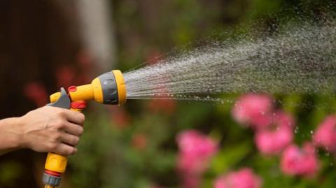 A yellow hosepipe spraying water