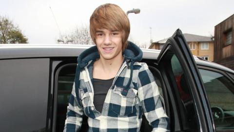 A young Liam Payne getting out of a people carrier with blacked-out windows outside a recording studio. 