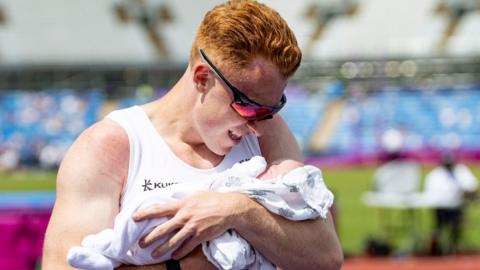 Alastair Chalmers cradles baby son Robert after winning British 400m hurdles title