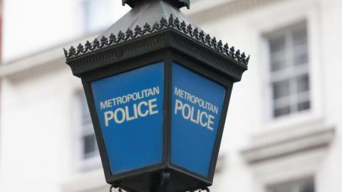 A lamppost which is blue and says Metropolitan Police in white on each pane