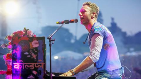 Chris Martin playing the piano.