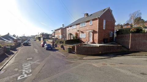 A street view of Parkway in Exeter. There are houses located wither side of the road and on the road it has white text which says 'Parkway'. There are vehicles parked either side of the road.