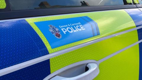 A police car door with a Devon and Cornwall Police logo on it.