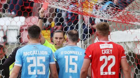 Stephen O'Donnell receiving a red card from referee Louise Thompson