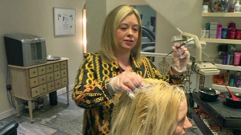 Chloe highlighting a customer's hair