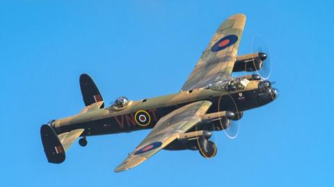 The Lancaster Bomber flying through bright blue skies piloted by Flight Lieutenant Davey during rehearsals for the coronation