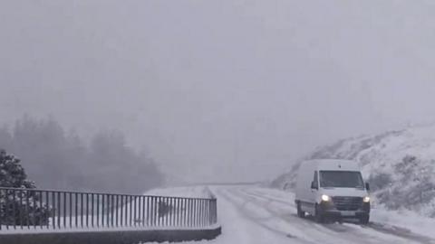 Van drives down snow-covered road