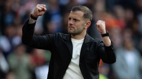 Jack Wilshere with his arms raised and fists clenched in celebration