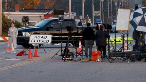 A road is closed as police continue to search for the suspected gunman